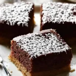 Freshly baked kefir sheet cake sliced into squares with a glossy chocolate glaze on a rustic table.