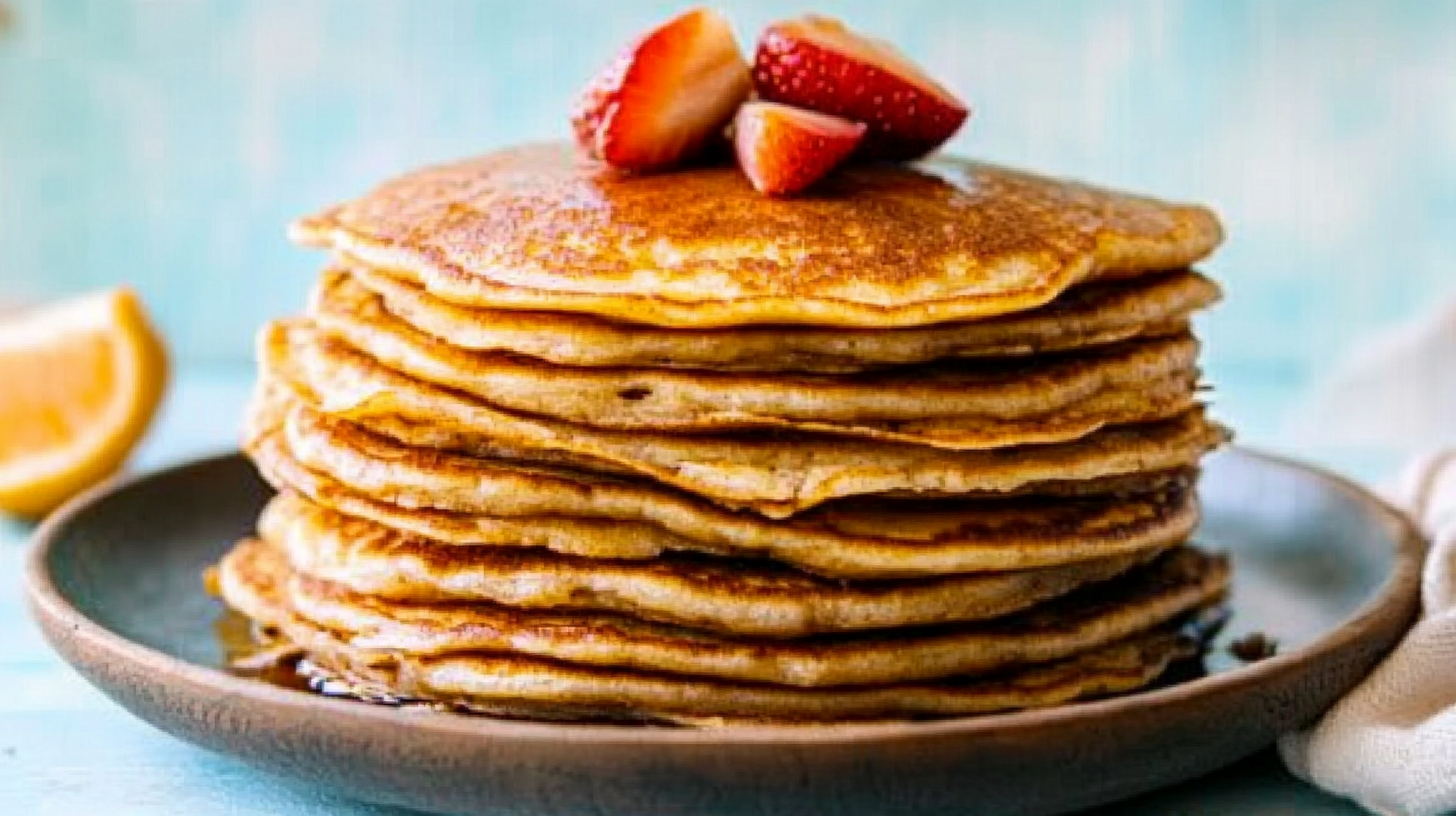 A simple yet mouthwatering photo of a stack of fluffy, golden-brown pancakes made without eggs, topped with syrup and fresh berries, captured in natural light on a rustic wooden table, showcasing a cozy, homemade feel