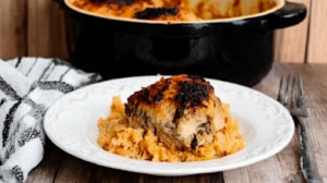 A beautifully plated serving of forgotten chicken casserole with tender chicken, creamy rice, and a garnish of fresh parsley, paired with steamed green beans and a side of crusty bread. 